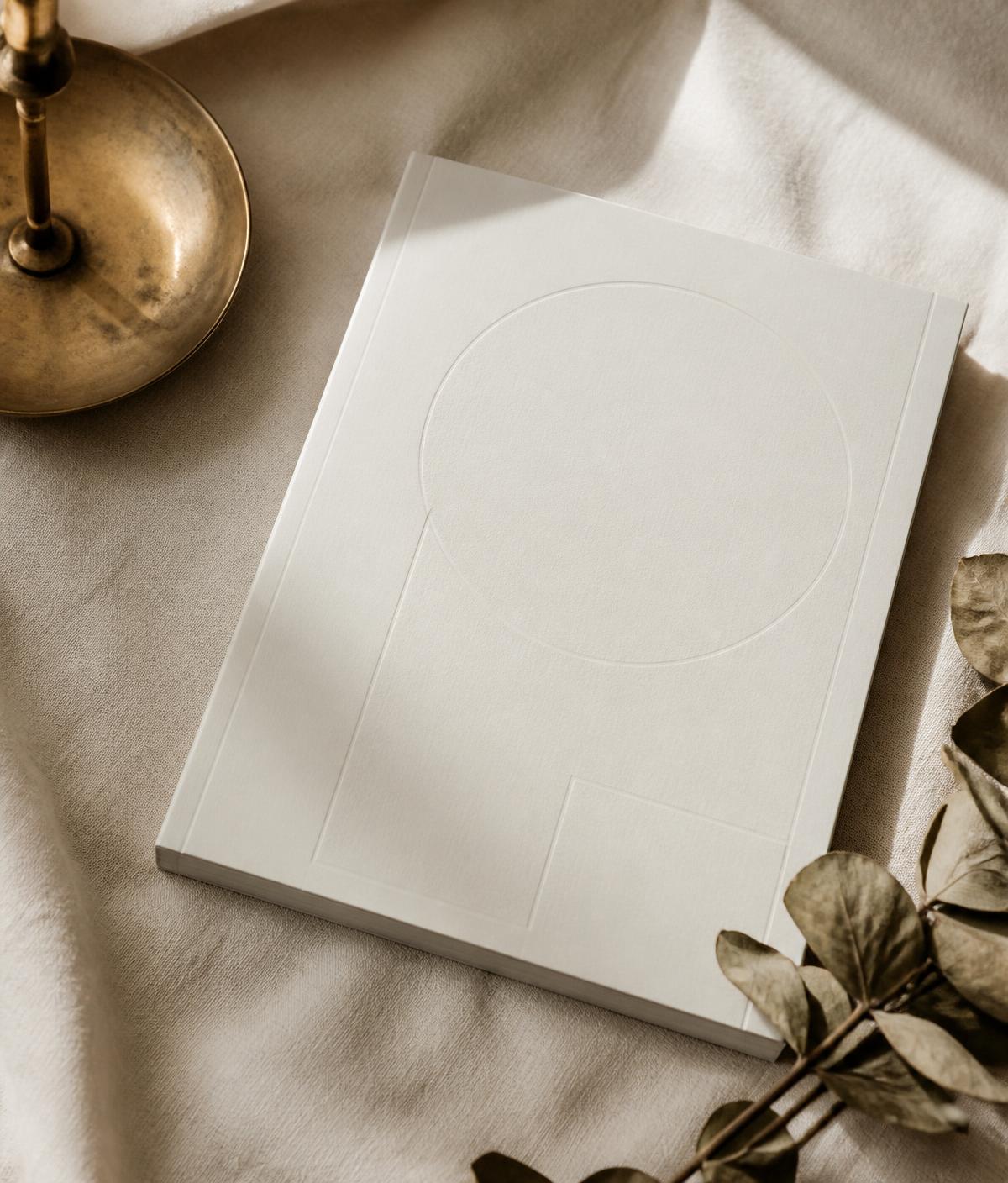 The printed Welcome Home Boston guide resting on cream linen beside a brass candlestick
