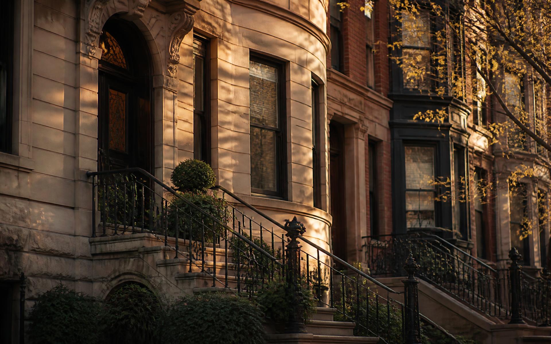 Sunlit Boston brownstone façade with wrought iron stoop railings